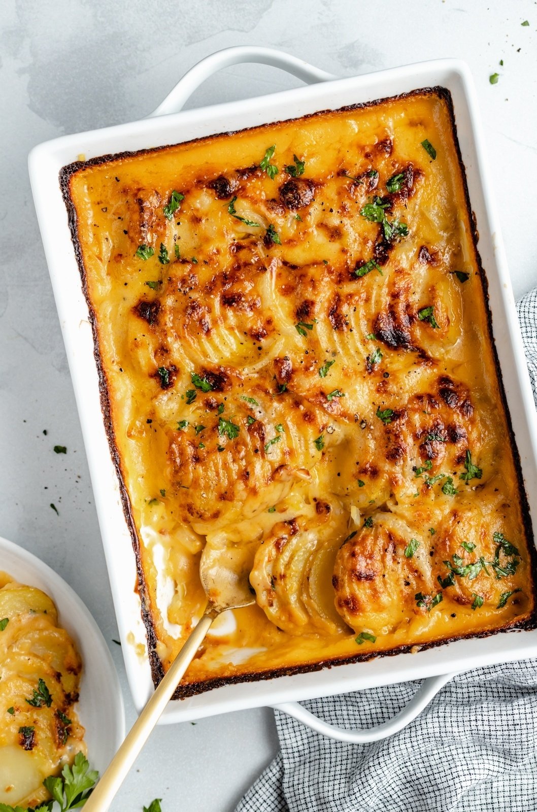 easy potatoes au gratin in a baking dish with a spoon