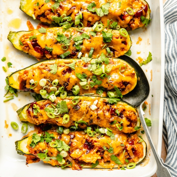 bbq chicken stuffed zucchini boats in a baking pan