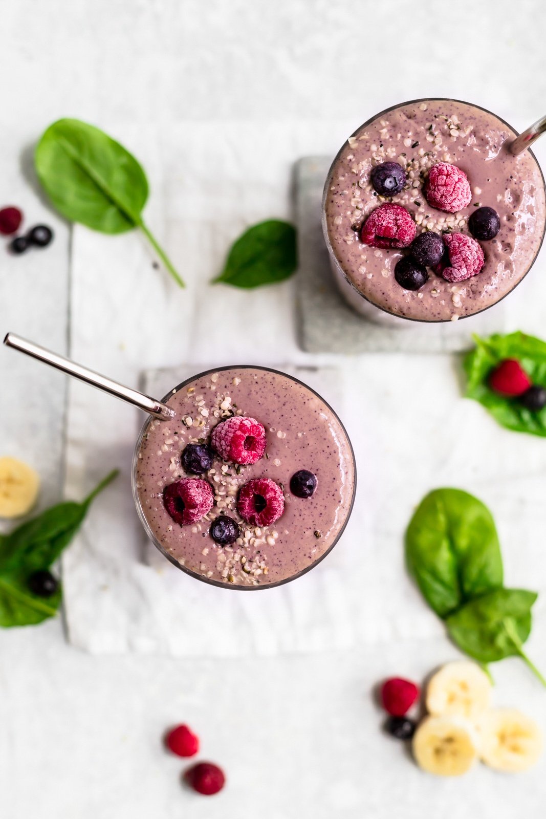 overhead shot of two purple berry smoothies