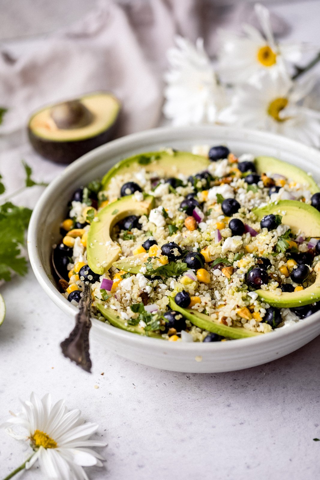 avocado blueberry salad in a bowl with a spoon