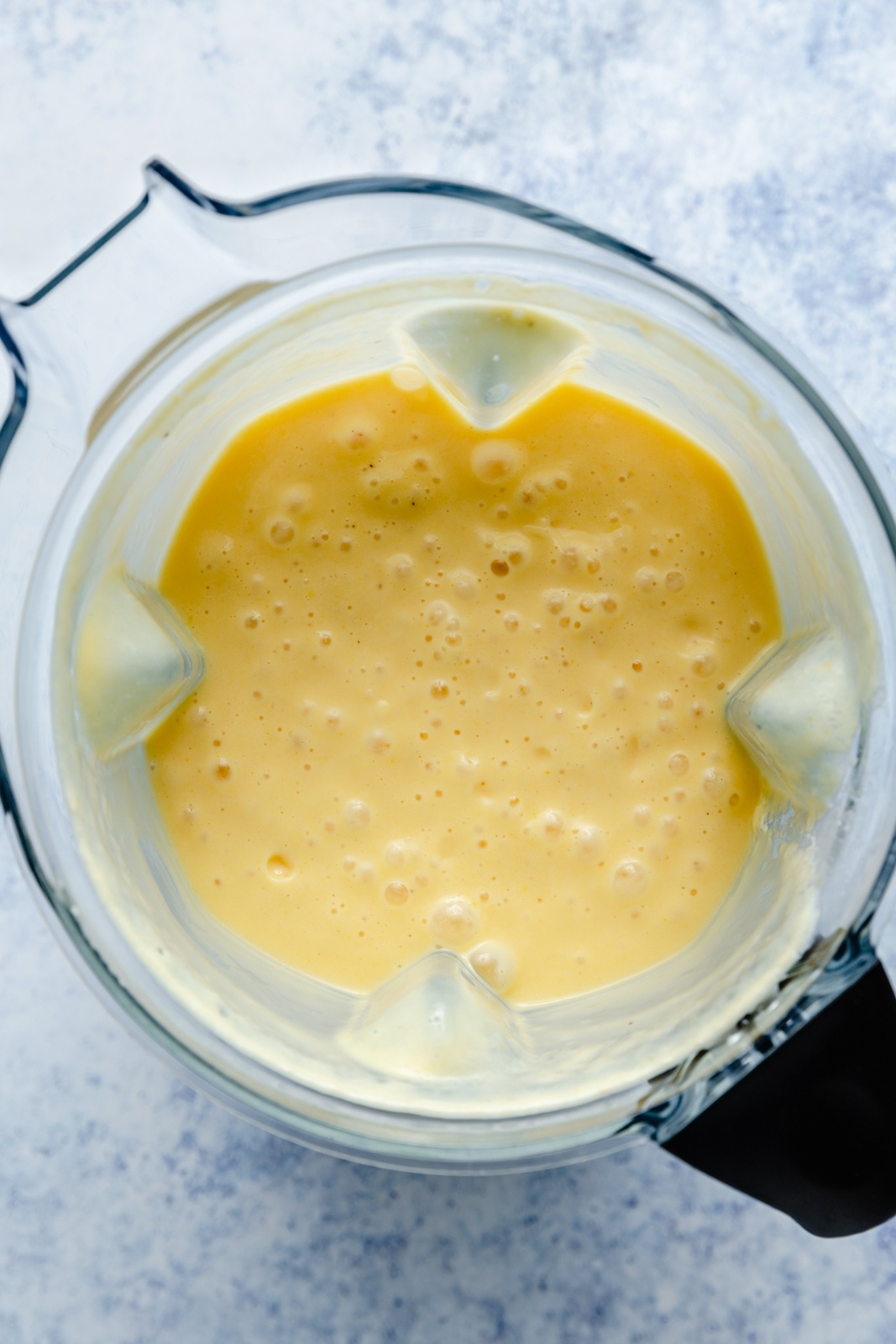 top-down view of a turmeric smoothie in a blender