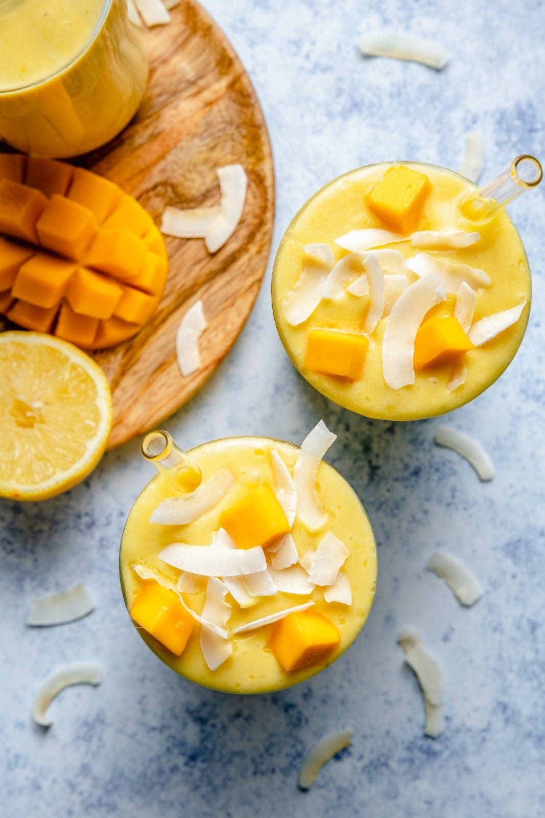 top-down view of two turmeric smoothies with mango and pineapple