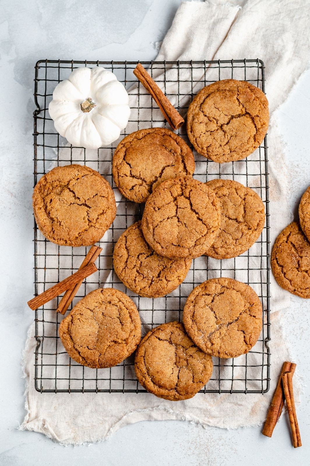 pumpkin snickerdoodles on a wire rack with a white pumpkin