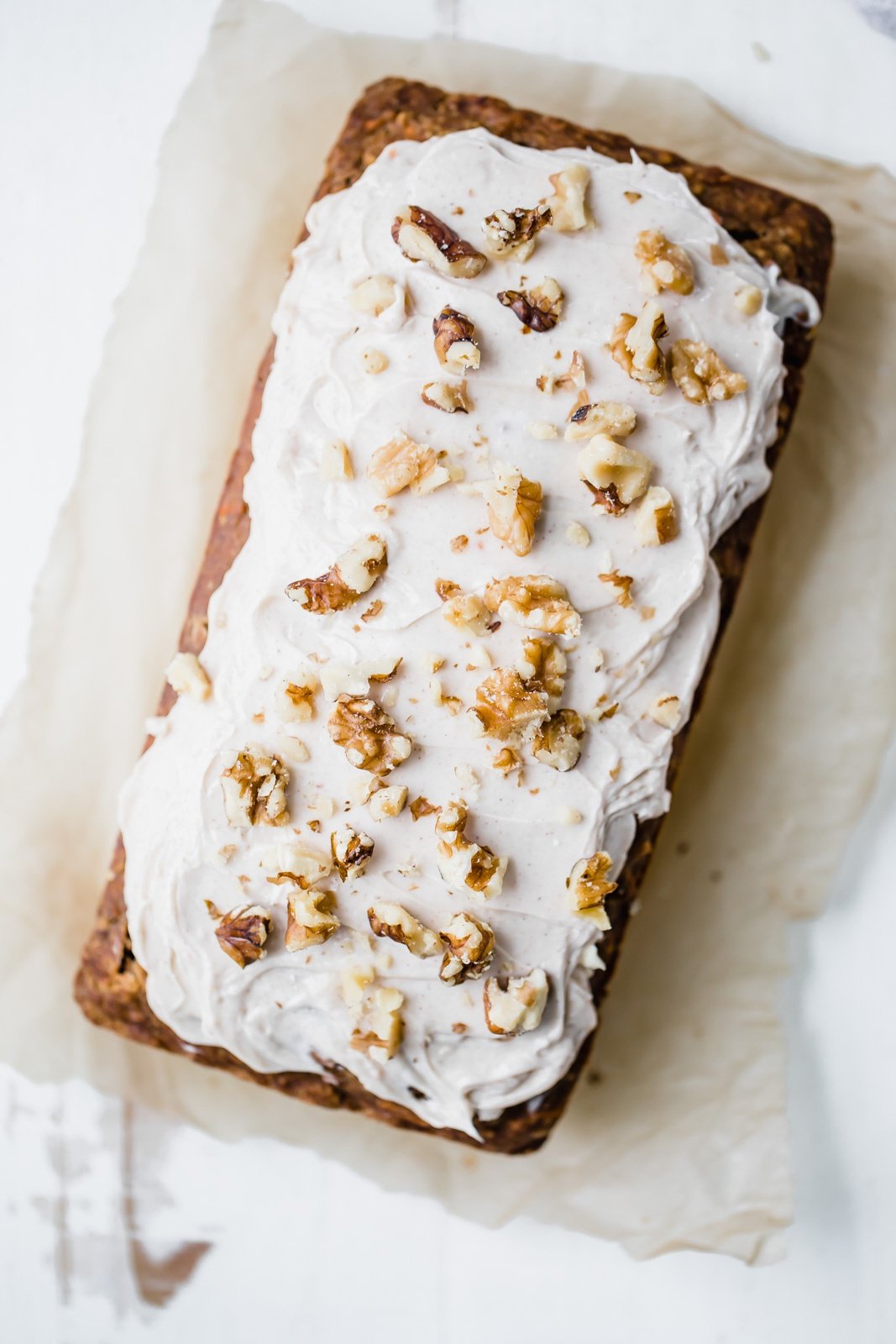 carrot cake banana bread with cream cheese frosting and walnuts on top