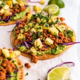 chipotle chicken tostada topped with pineapple salsa on parchment paper