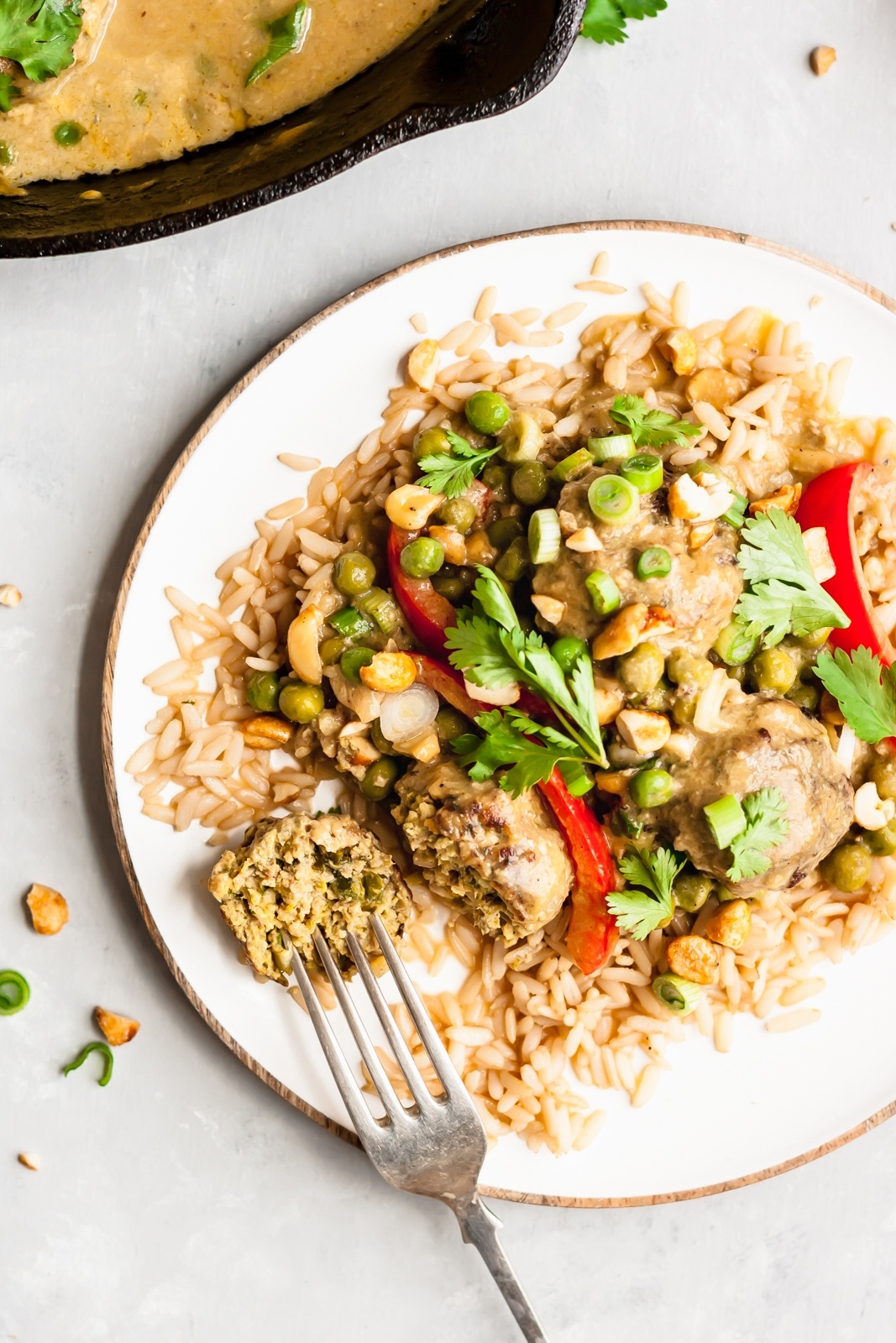 cilantro chicken meatballs with mango coconut sauce on a plate with a fork