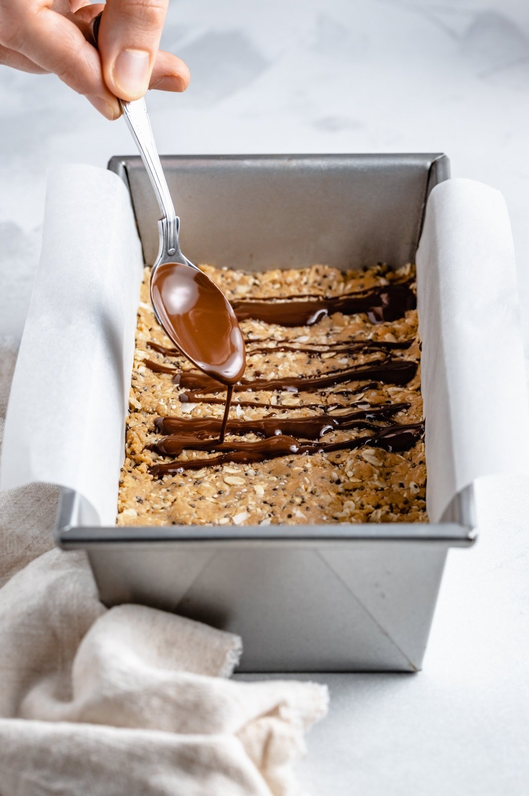 drizzling chocolate onto coconut protein bars