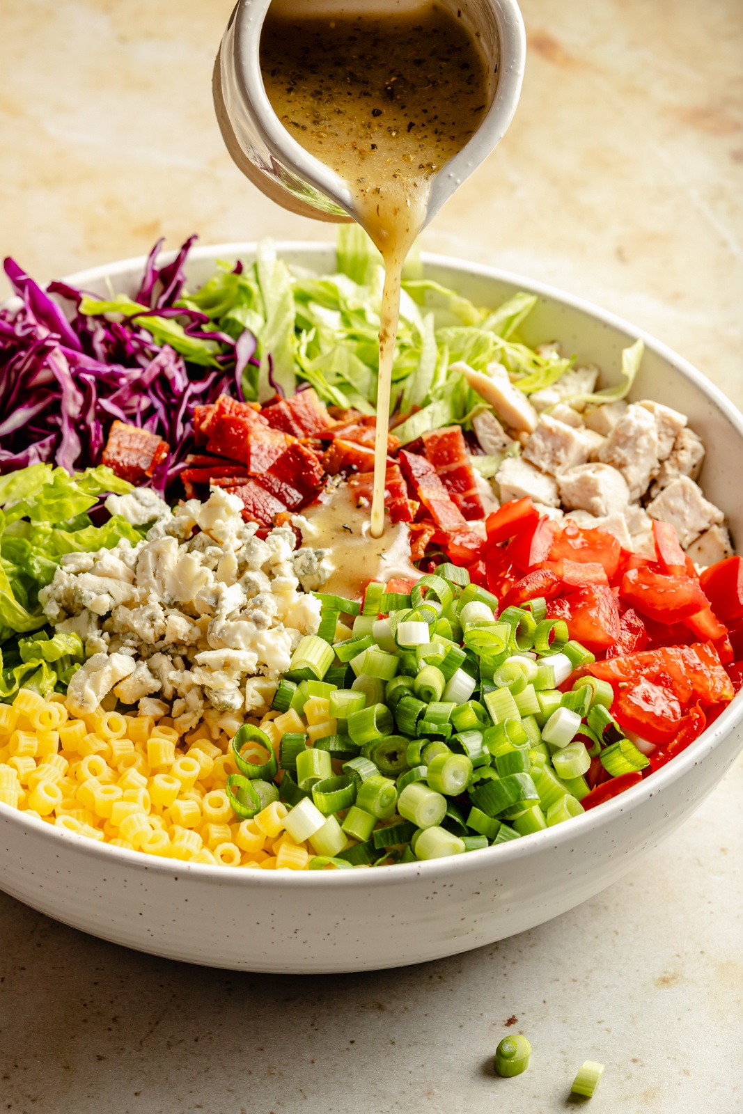 pouring dressing onto a copycat portillo's chopped salad