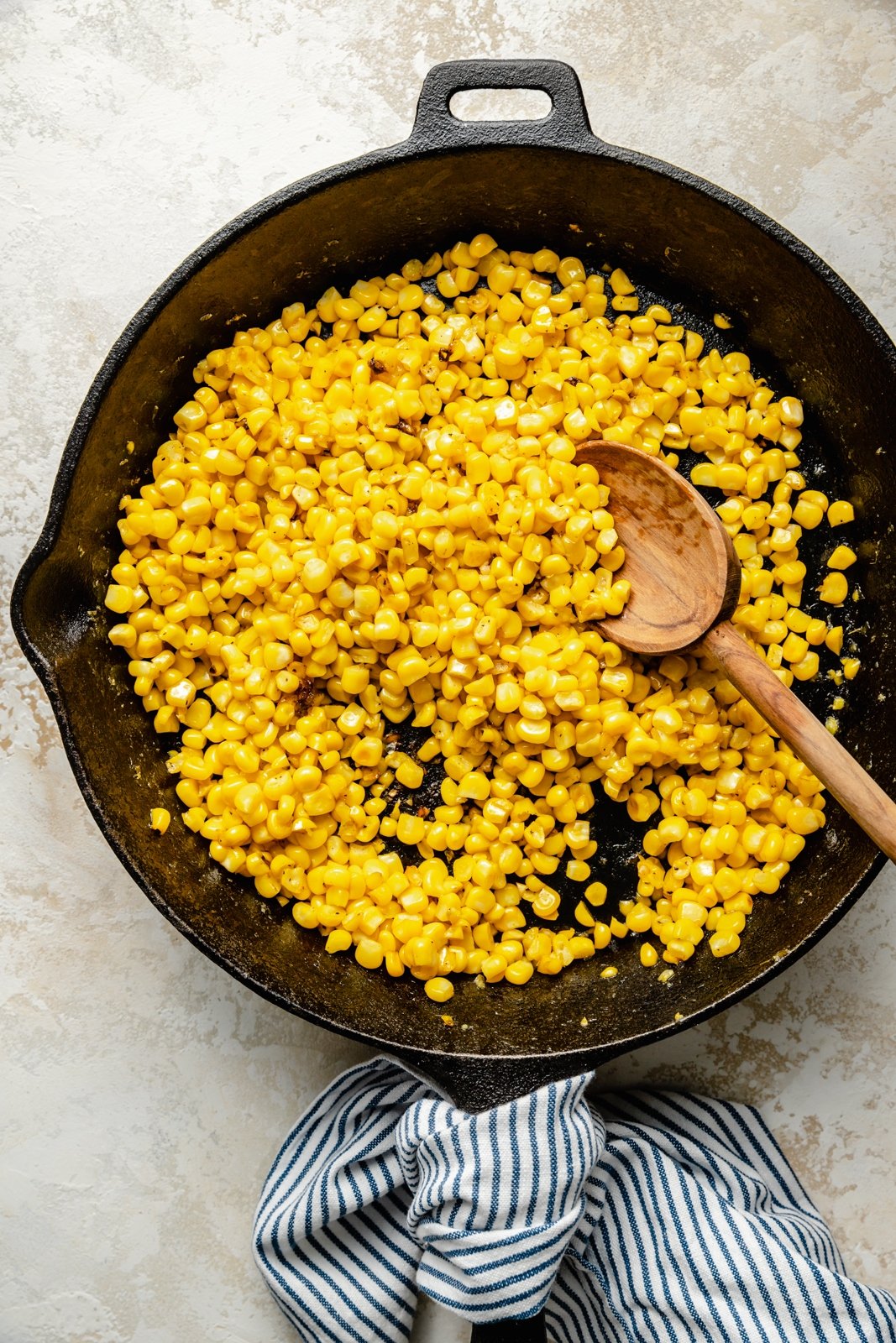 cooking corn in a skillet to make corn and ricotta pasta