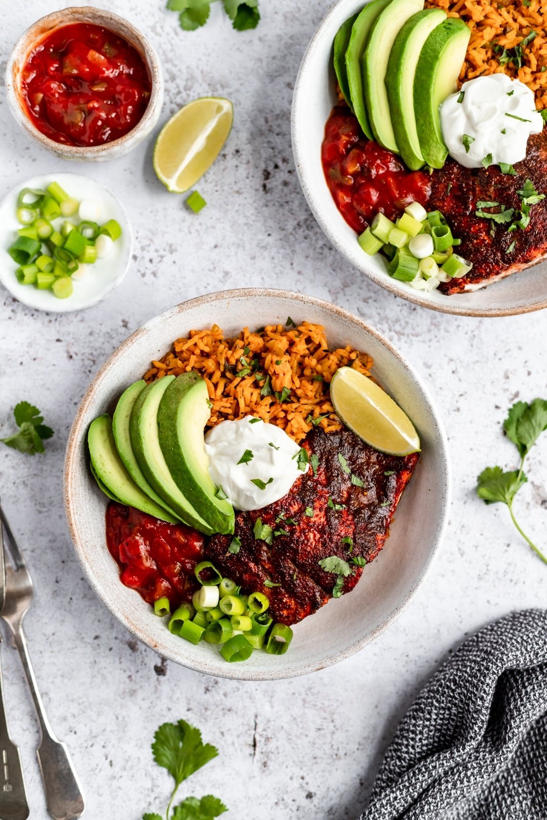 healthy salmon taco bowls with avocado and lime wedges