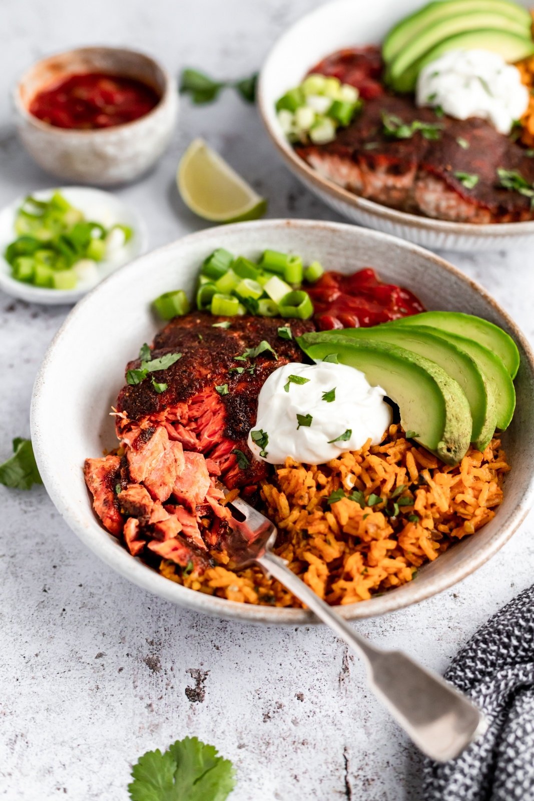 healthy salmon taco bowl topped with greek yogurt and avocado slices