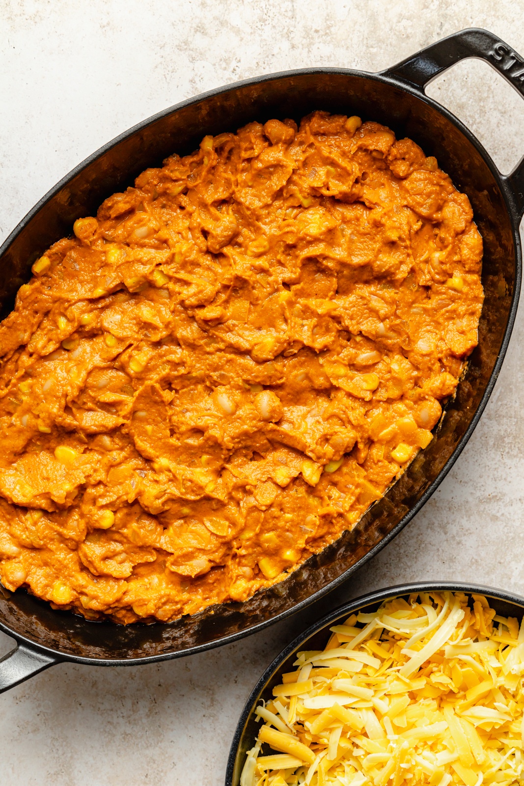 layering an easy southwest bean dip in a skillet