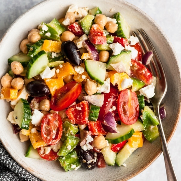 greek chickpea salad in a bowl with a fork