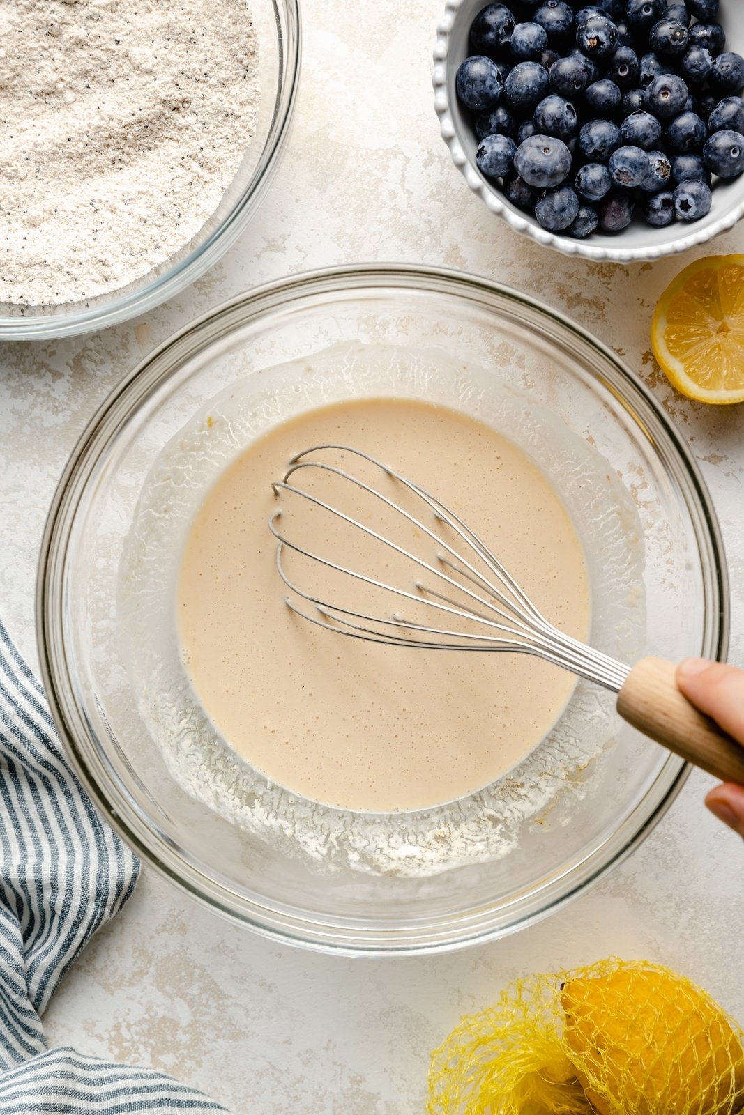 whisking batter for lemon blueberry pancakes in a bowl