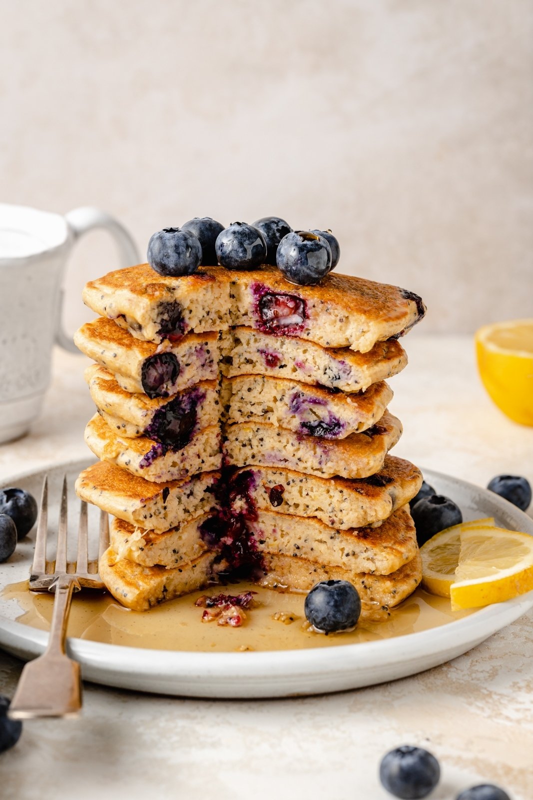 sliced stack of blueberry lemon pancakes on a plate