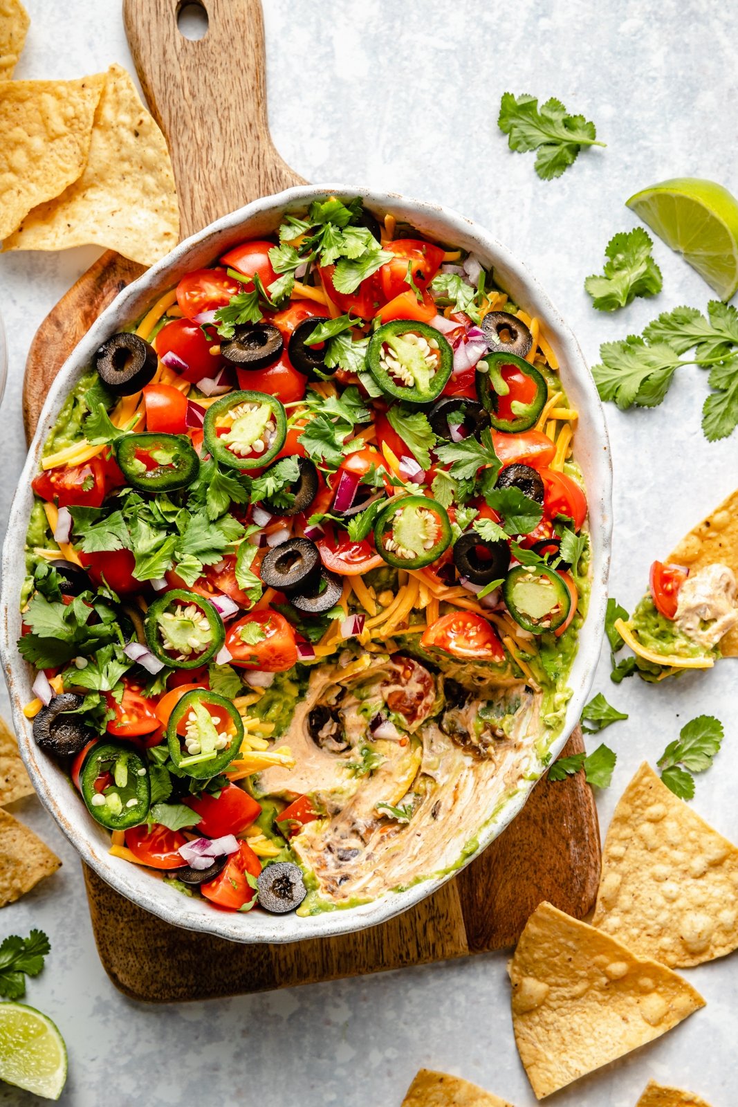 7-layer dip in a serving bowl next to tortilla chips