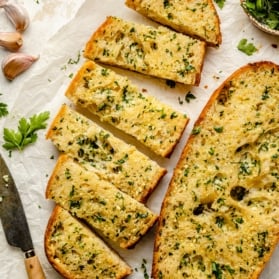 homemade garlic bread sliced on parchment paper