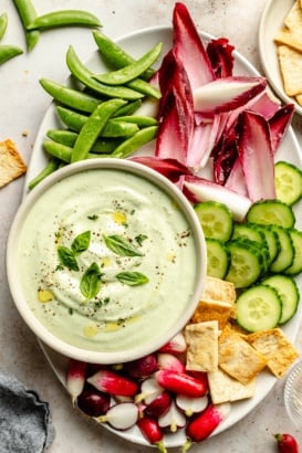 herb cottage cheese dip in a bowl with a platter of vegetables