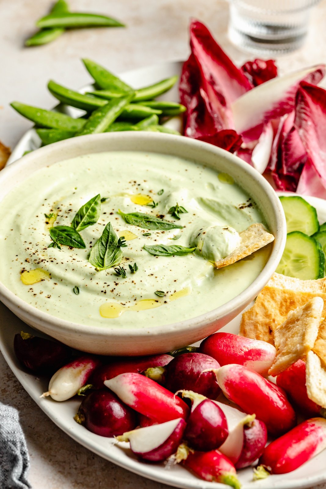 healthy herb cottage cheese dip in a bowl next to vegetables