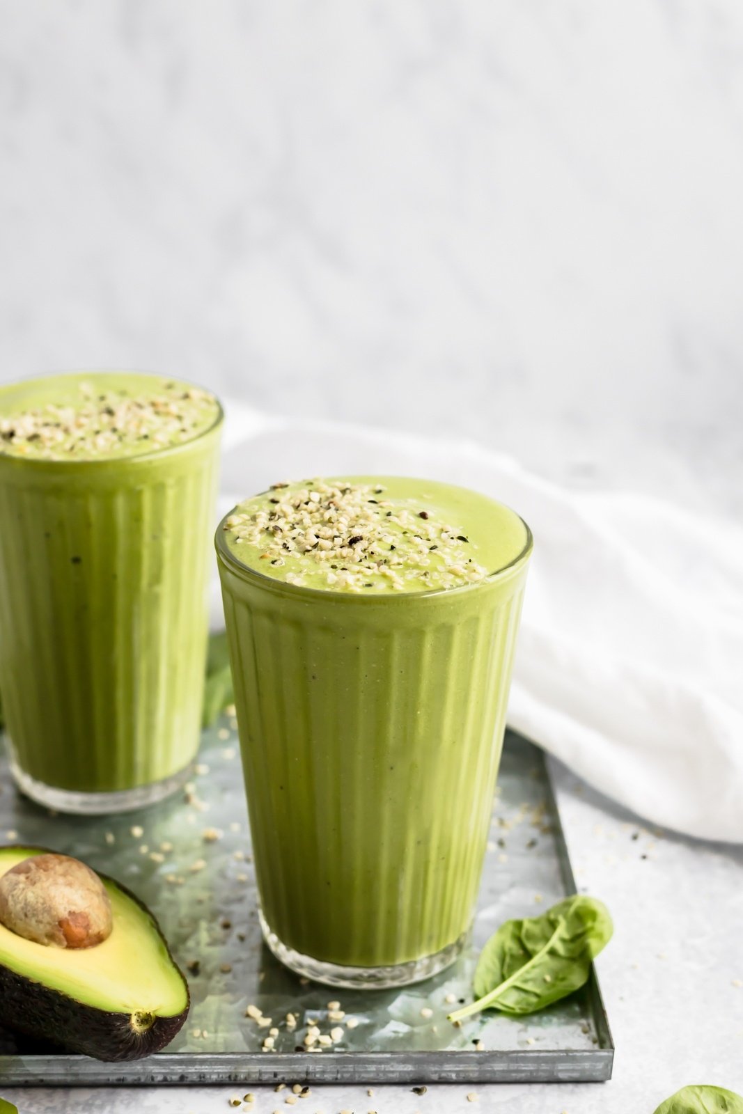 two greens smoothies topped with hemp seeds