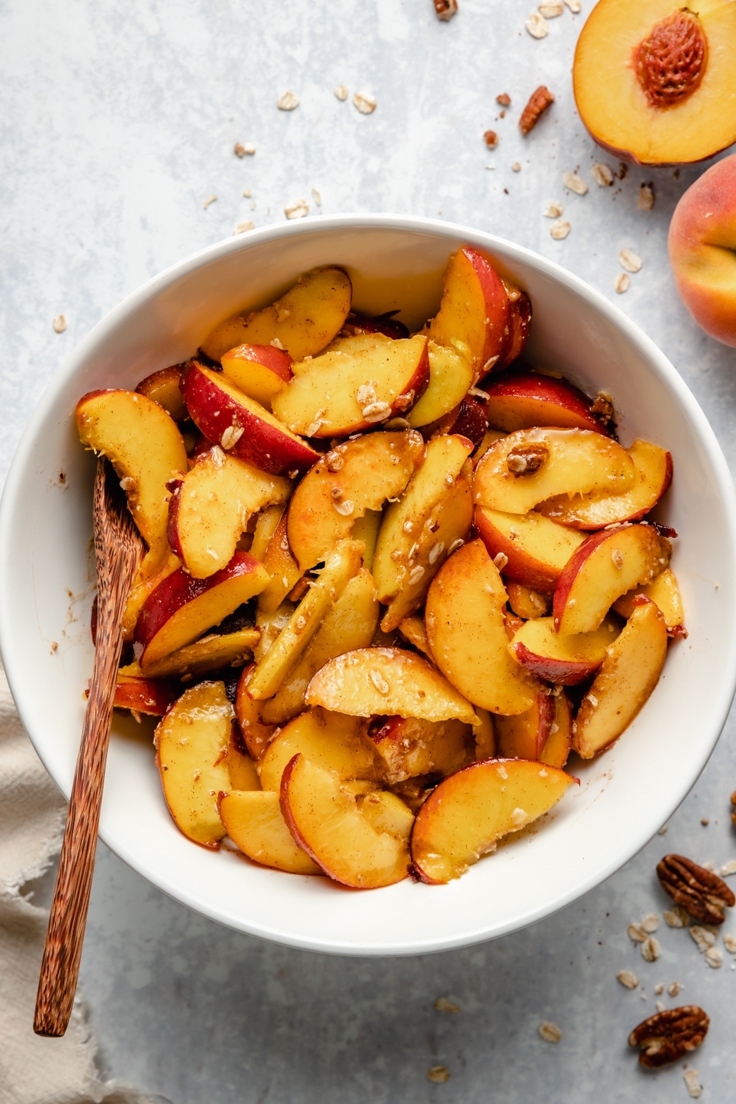 mixing peaches in a bowl for a healthy peach crisp