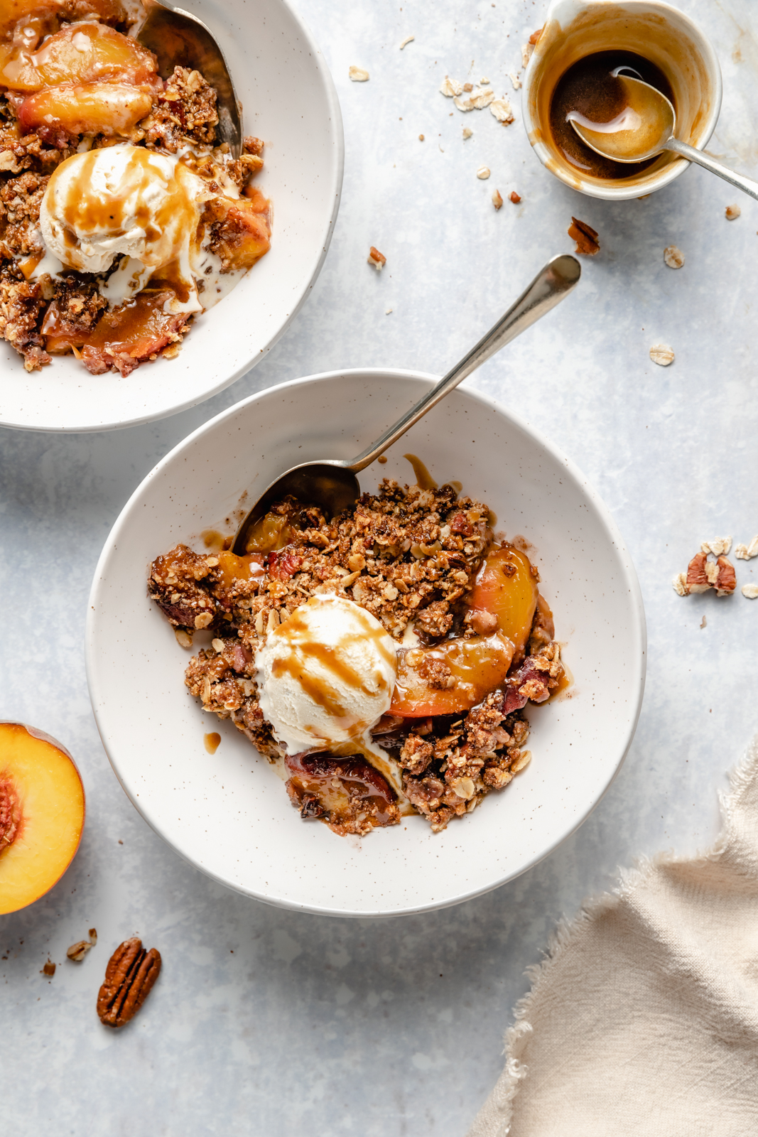 gluten free peach crisp in a bowl topped with ice cream