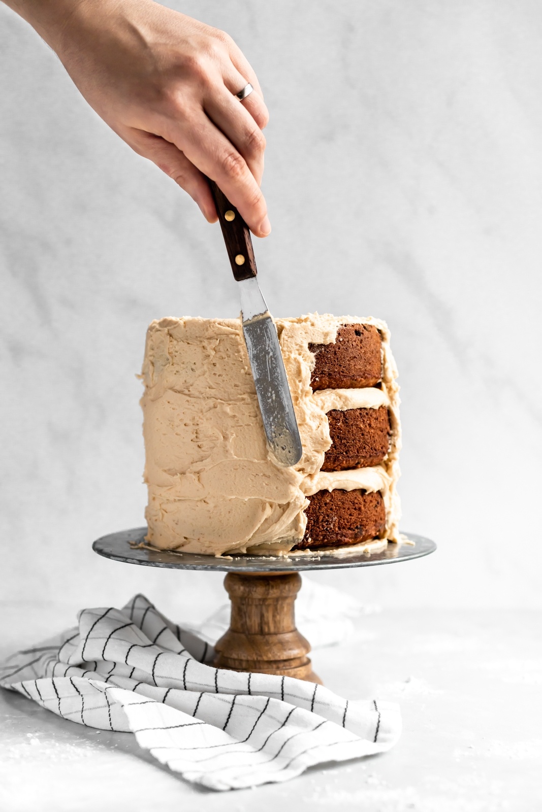 frosting a grain free peanut butter banana cake with peanut butter frosting