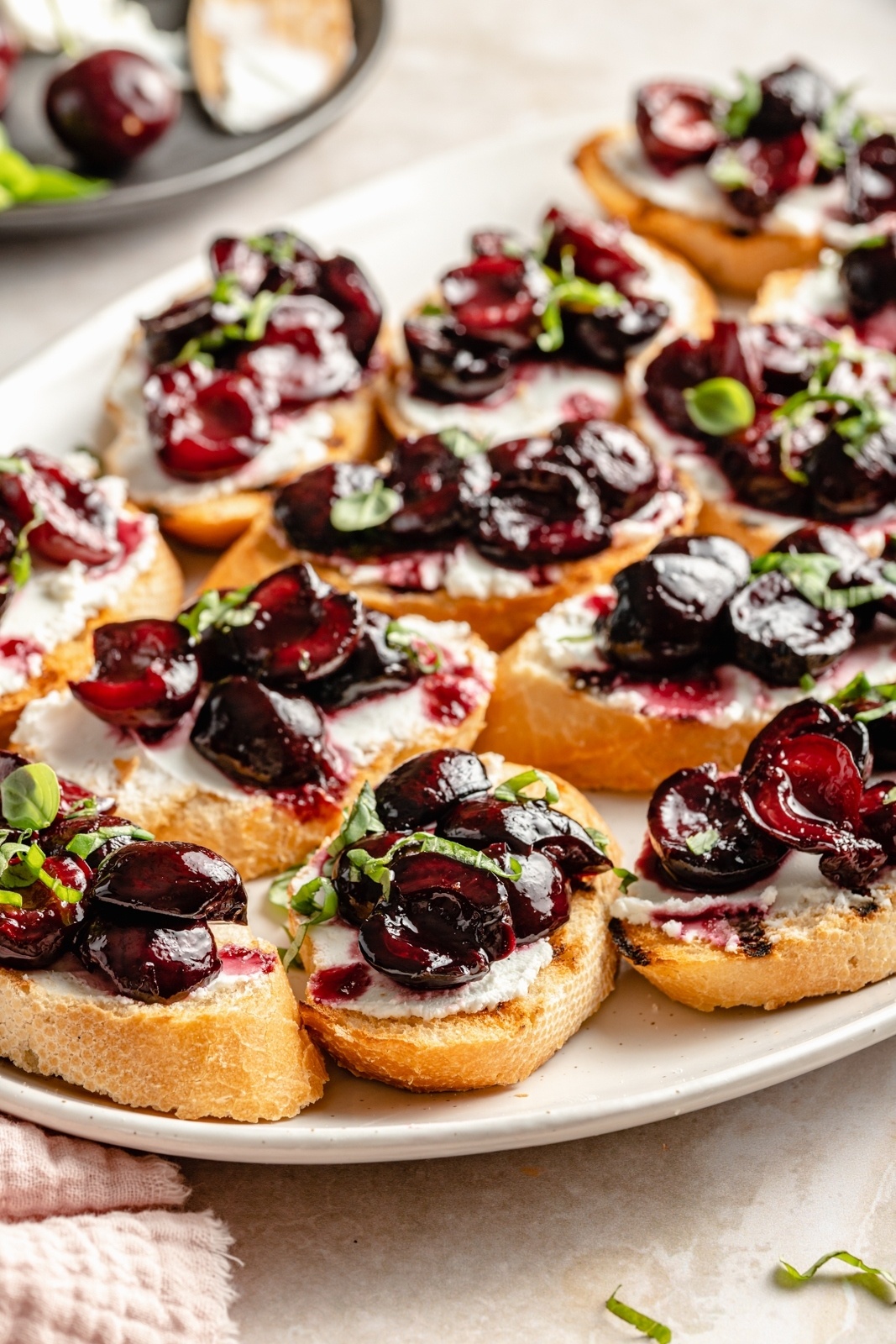 grilled crostini with roasted cherries and goat cheese on a platter