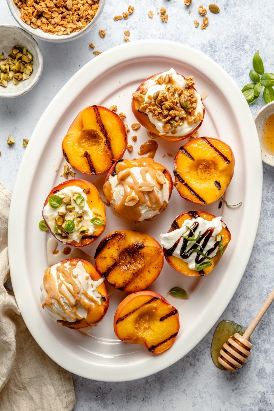 grilled peaches with various toppings on a platter