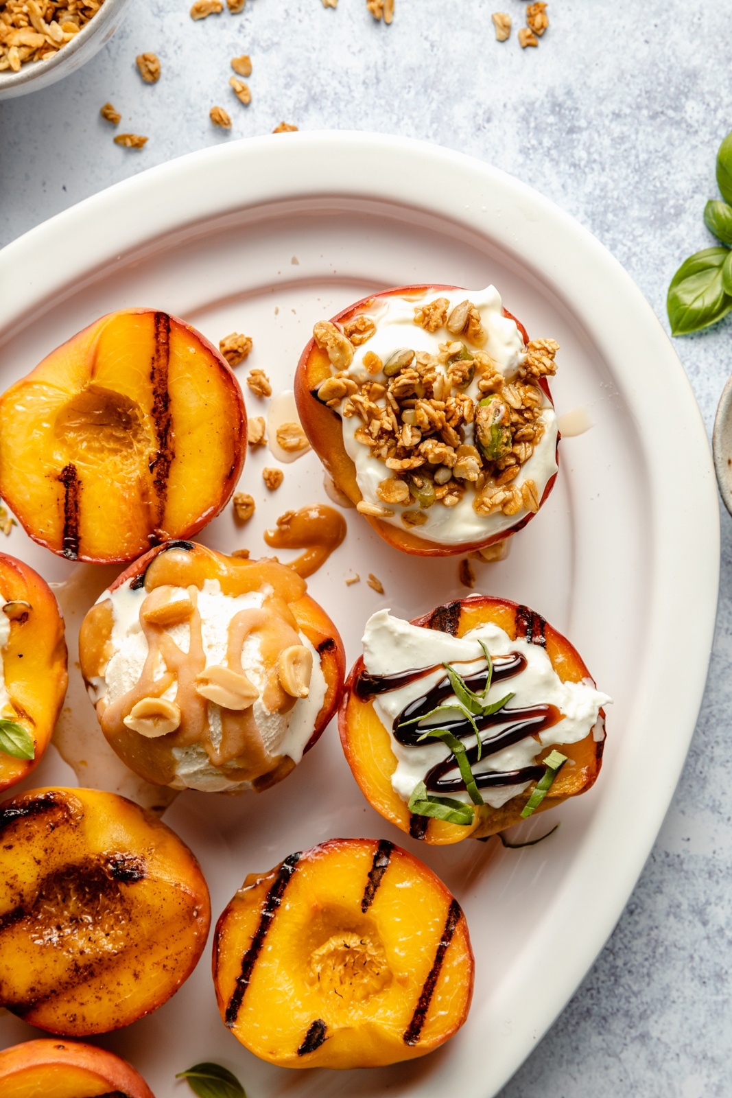 grilled peaches on a platter with different toppings