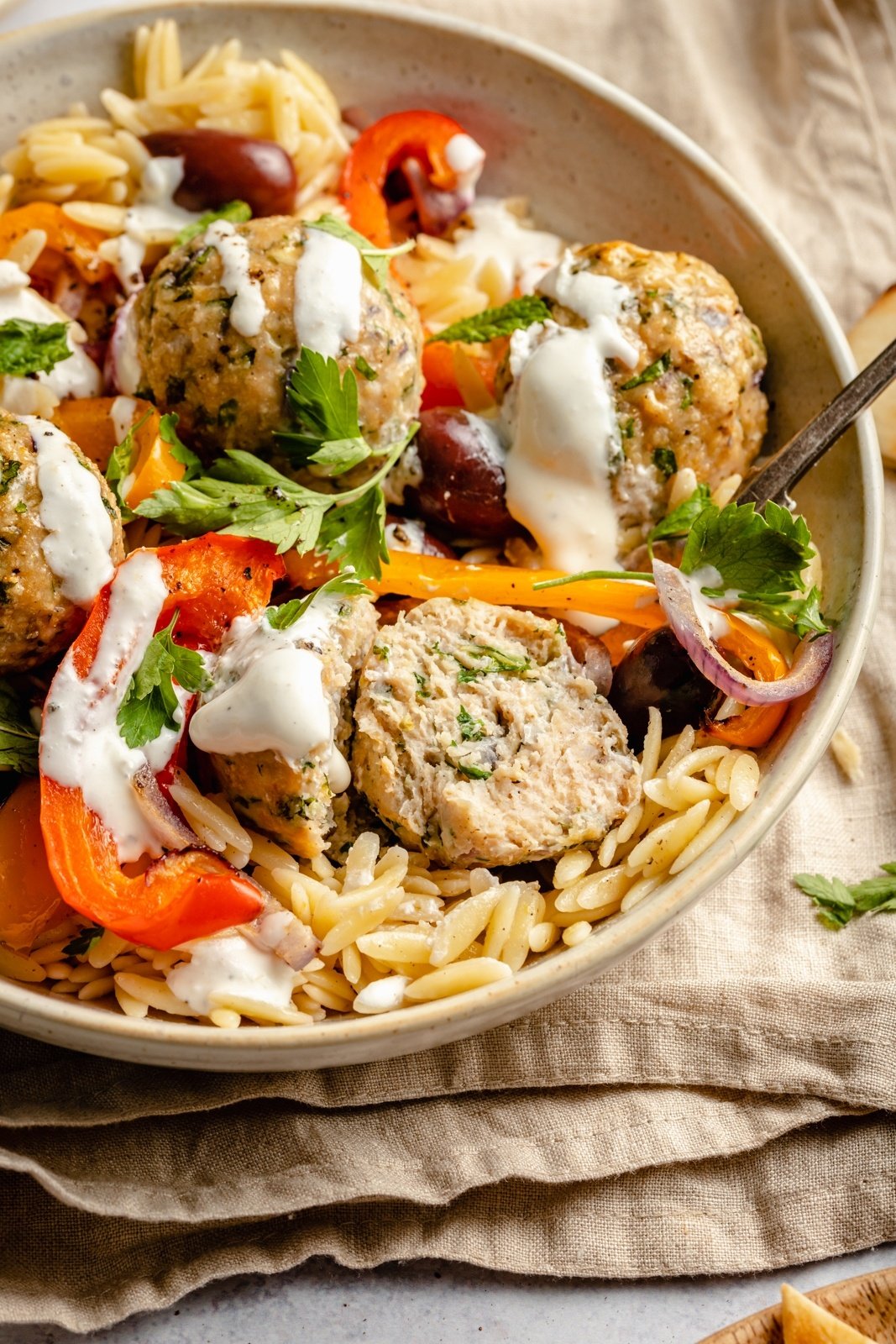 Greek turkey meatballs with veggies and orzo in a bowl