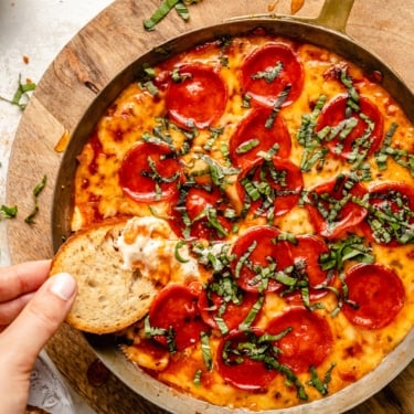 dipping a crostini in pizza dip