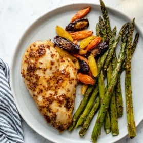 baked chicken breast on a plate with vegetables