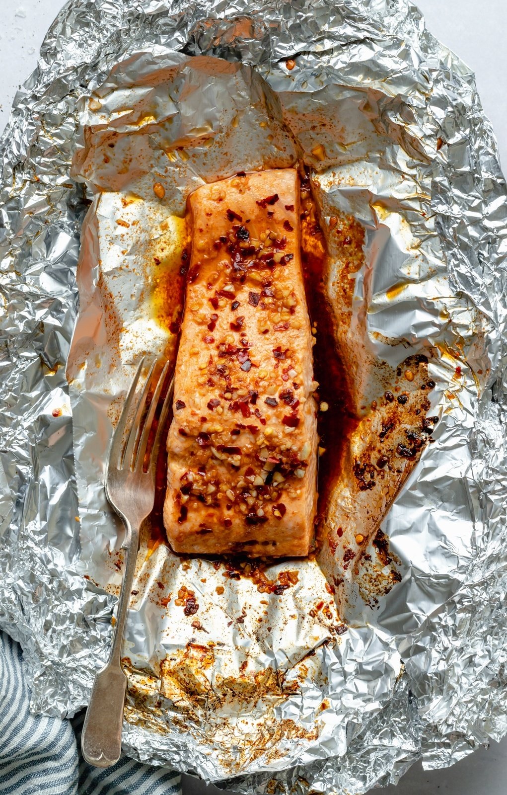 salmon in a foil pack with a fork