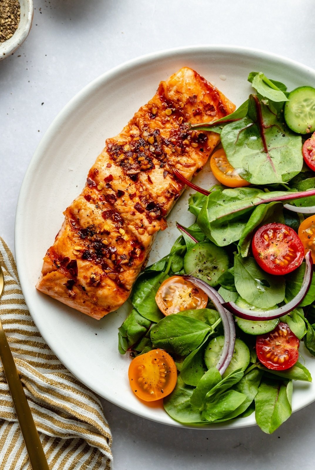 grilled salmon on a plate with a salad