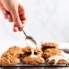 maple pecan oatmeal cookies being topped with a salted maple icing