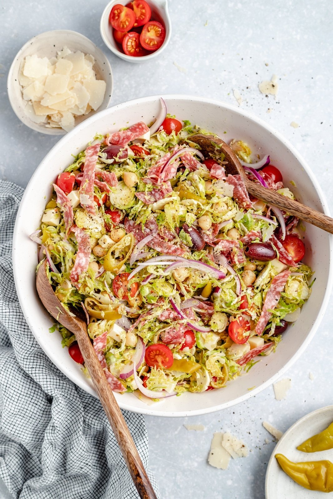 easy italian chopped salad with brussels sprouts in a bowl with wooden tongs