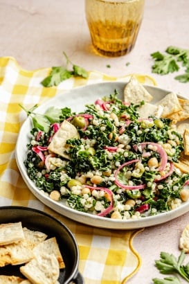kale couscous salad on a plate with pita chips