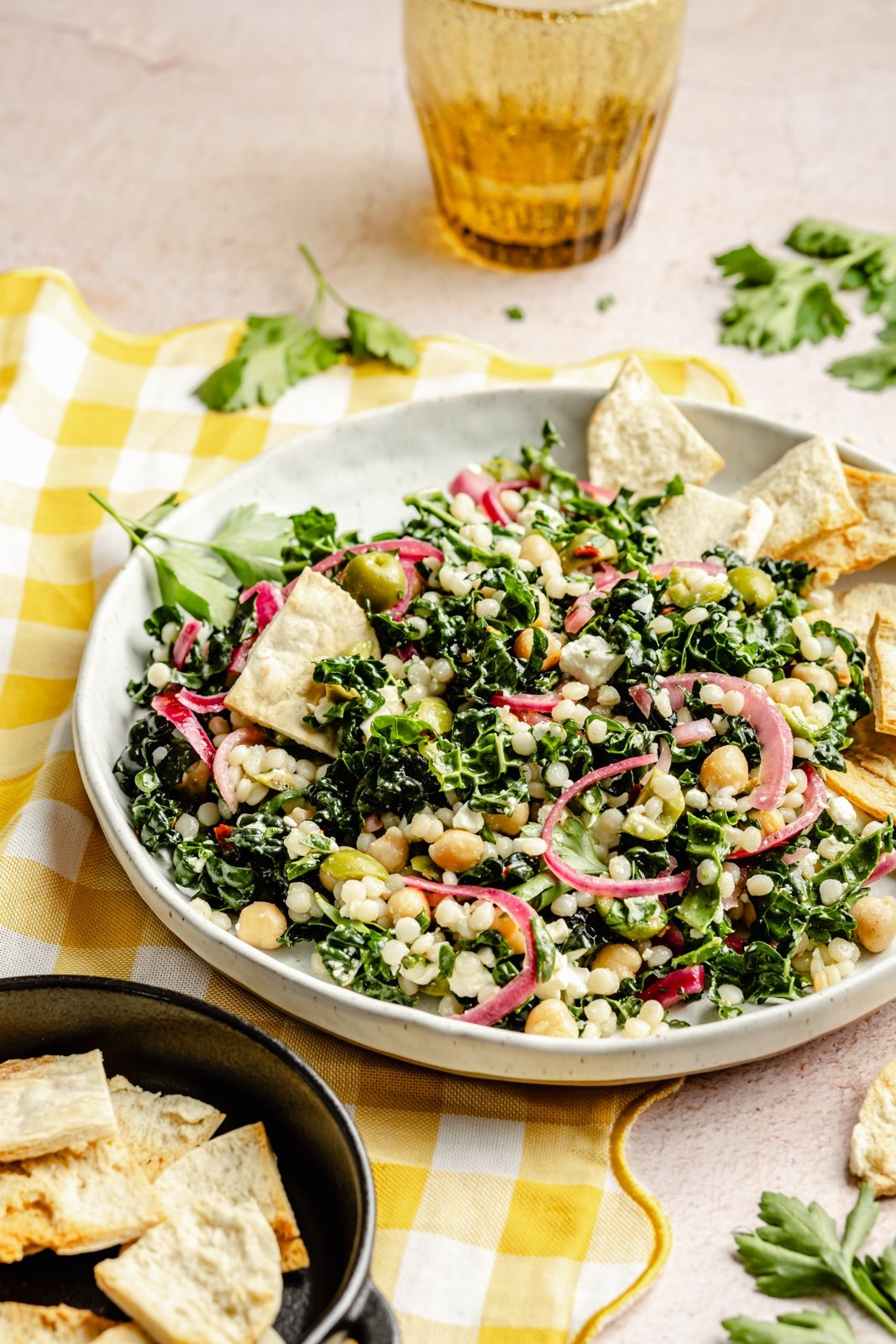 kale couscous salad in a bowl with pita chips