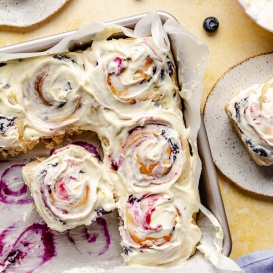 lemon blueberry sweet rolls with lemon frosting in a square pan