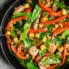 mango chicken stir fry in a skillet pan