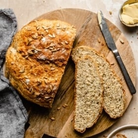 honey oatmeal artisan bread sliced on a wooden board