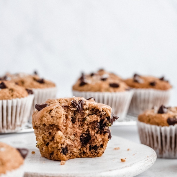 healthy chocolate chip zucchini muffin on a plate with a bite taken out