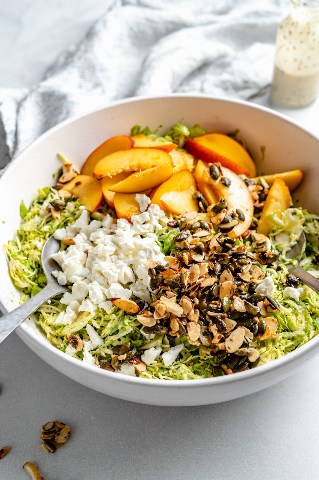 brussels sprouts peach salad with nuts and feta cheese in a bowl