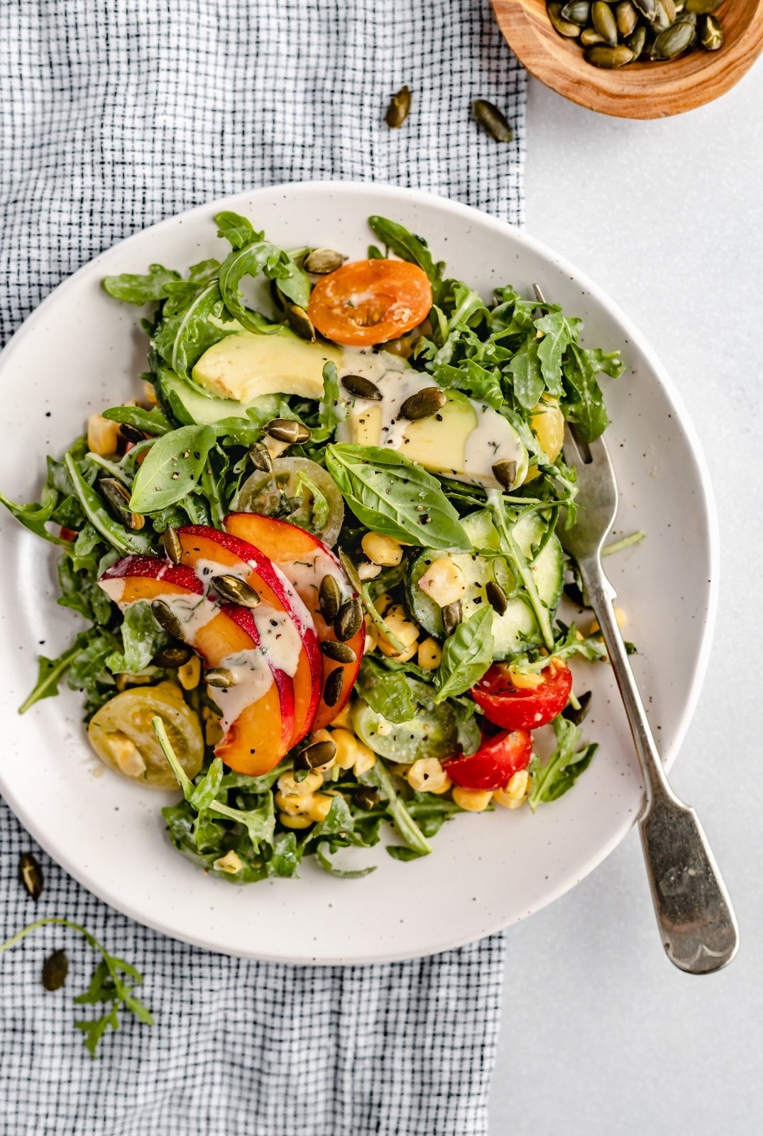 peach tomato salad in a bowl with a fork