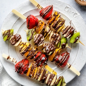 fruit skewers with chocolate on a plate