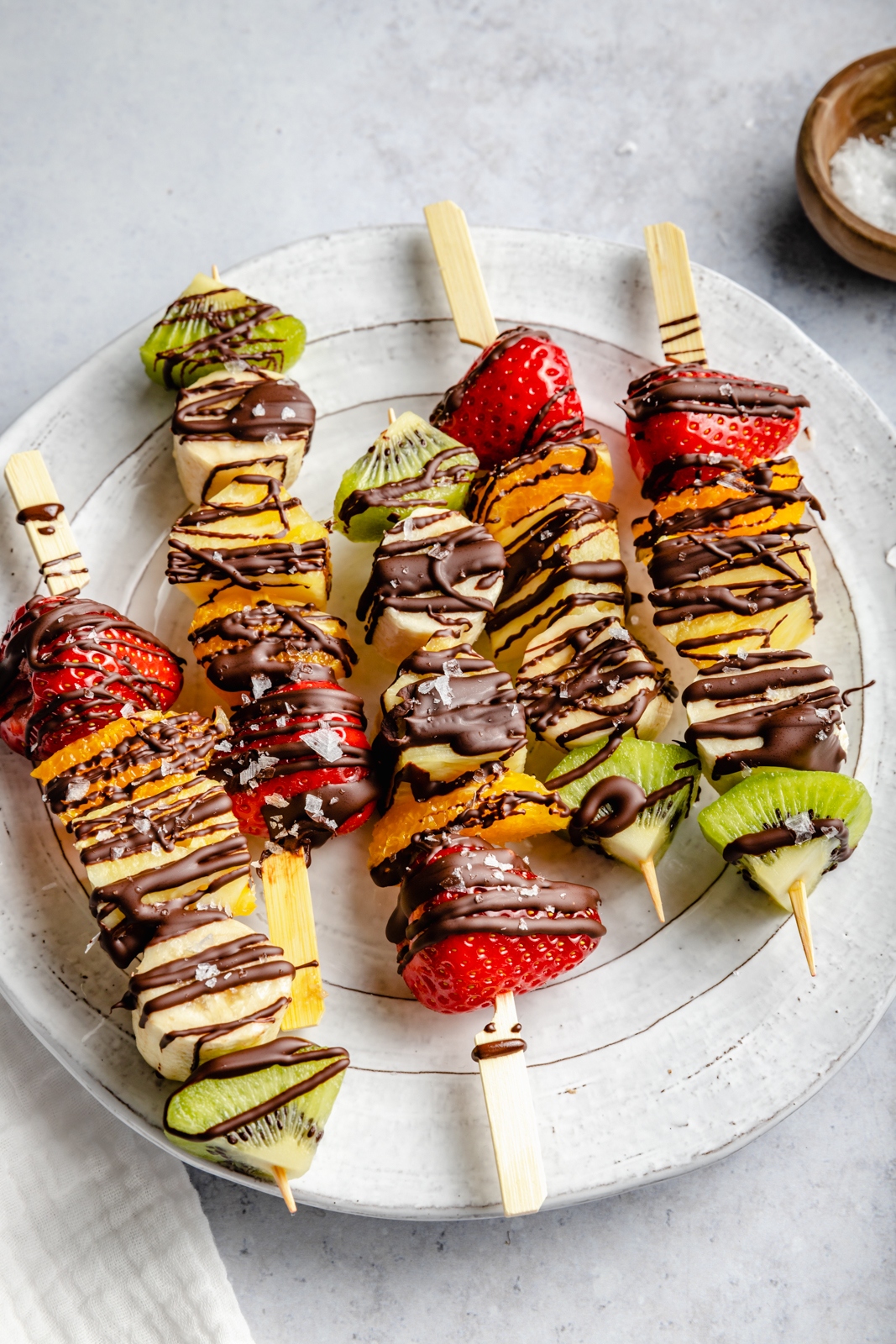 fruit kabobs with chocolate on a plate