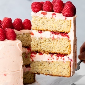 pulling a slice of lemon raspberry cake out of the cake