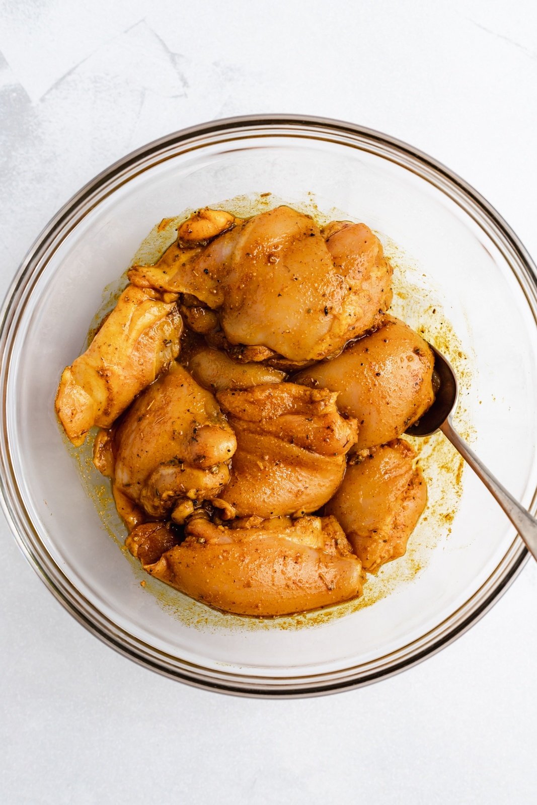 chicken thighs in a bowl of sazon seasoning