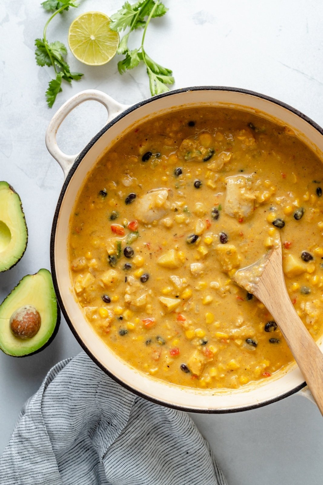 southwest corn chowder in a pot with a wooden spoon